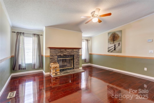 4630 Irish Potato Rd, Kannapolis, NC 28083 - unfurnished living room with wood finished floors, ceiling fan, a textured ceiling, ornamental molding, and a stone fireplace