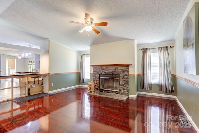 4630 Irish Potato Rd, Kannapolis, NC 28083 - unfurnished living room with plenty of natural light, ornamental molding, a stone fireplace, ceiling fan, and a textured ceiling