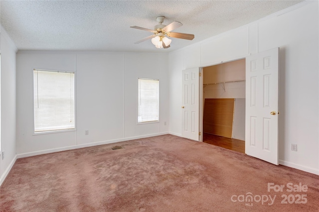 4630 Irish Potato Rd, Kannapolis, NC 28083 - unfurnished bedroom with carpet flooring, a textured ceiling, multiple windows, a walk in closet, and a ceiling fan