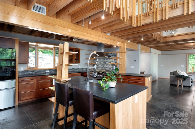 588 Long Branch Rd, Swannanoa, NC 28778 - kitchen featuring dark countertops, refrigerator, rail lighting, a kitchen island with sink, and beam ceiling