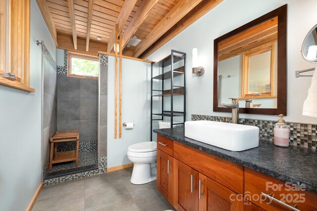 588 Long Branch Rd, Swannanoa, NC 28778 - bathroom with wooden ceiling with exposed beams, vanity, toilet, tiled shower, and baseboards
