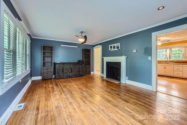 8255 Castor Rd, Salisbury, NC 28146 - unfurnished living room featuring light wood-style floors, crown molding, baseboards, a brick fireplace, and a sink