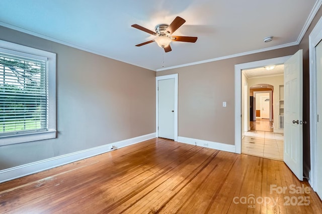 8255 Castor Rd, Salisbury, NC 28146 - unfurnished bedroom featuring hardwood / wood-style flooring, baseboards, arched walkways, ornamental molding, and ceiling fan