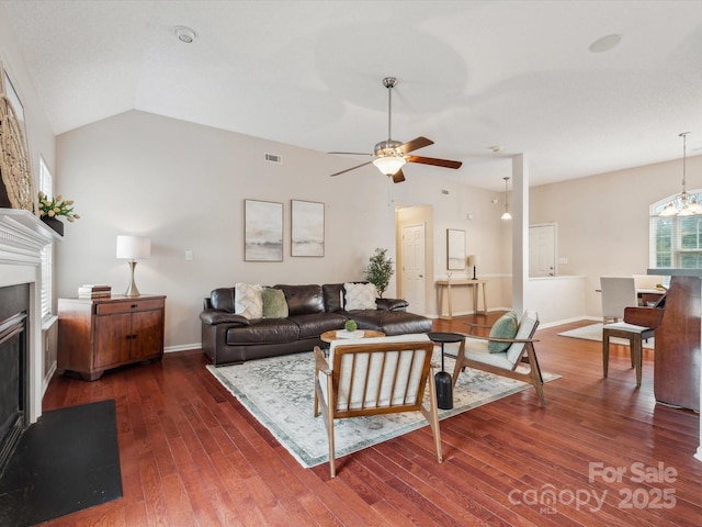 116 Birchwood Ct, Mount Holly, NC 28120 - living area featuring vaulted ceiling, a ceiling fan, wood finished floors, a glass covered fireplace, and a chandelier