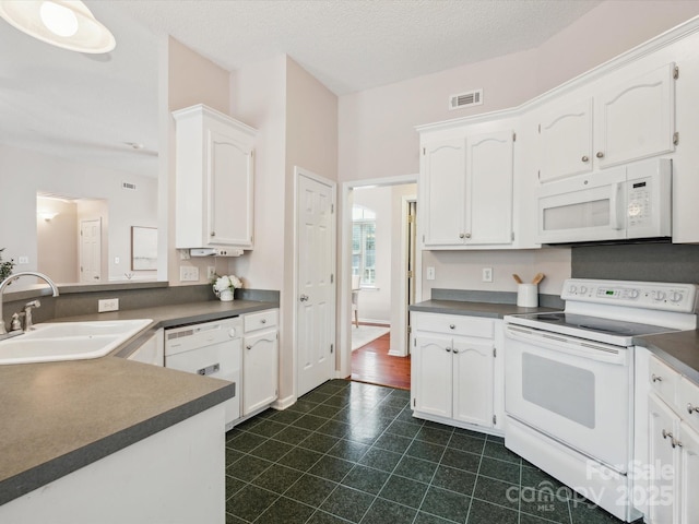 116 Birchwood Ct, Mount Holly, NC 28120 - kitchen with white appliances, dark countertops, white cabinets, and dark tile patterned flooring