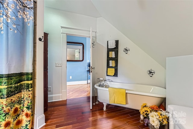 200 W 14th St, Salisbury, NC 28144 - bathroom with a soaking tub, wood finished floors, vaulted ceiling, baseboards, and toilet