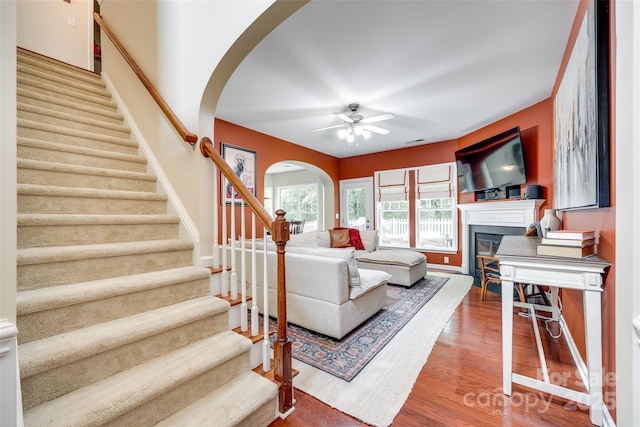 288 Sand Paver Way Unit 50, Fort Mill, SC 29708 - living room featuring arched walkways, stairs, a ceiling fan, a glass covered fireplace, and wood finished floors