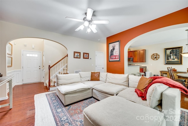 288 Sand Paver Way Unit 50, Fort Mill, SC 29708 - living room with arched walkways, light wood-style flooring, ceiling fan, stairway, and a wainscoted wall