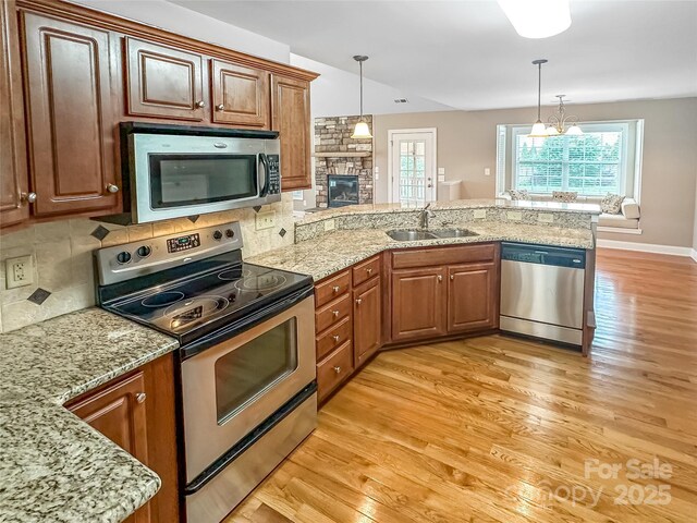 1625 Damascus Cir, Conover, NC 28613 - kitchen with appliances with stainless steel finishes, a sink, a peninsula, light wood-type flooring, and decorative light fixtures
