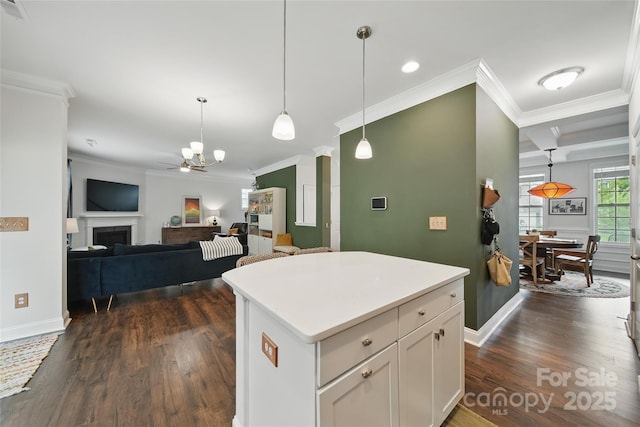2034 Houle Ln, Charlotte, NC 28214 - kitchen with crown molding, dark wood-style flooring, white cabinets, hanging light fixtures, and a kitchen island