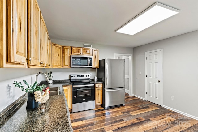 729 Tenth Ave NE, Hickory, NC 28601 - kitchen featuring appliances with stainless steel finishes, a sink, dark countertops, dark wood-style floors, and baseboards