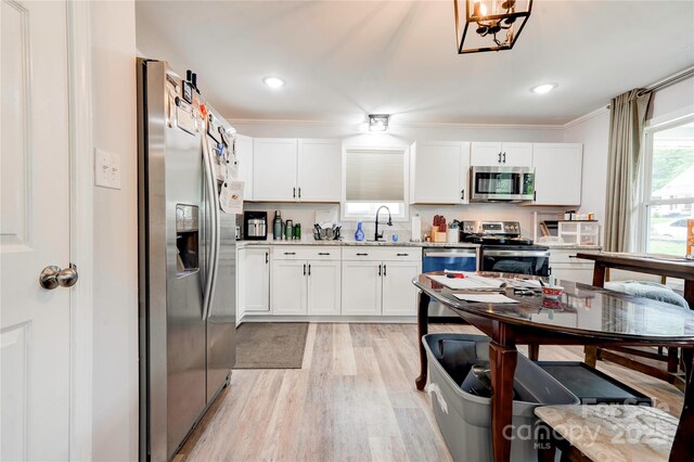 812 Kings Rd, Shelby, NC 28150 - kitchen with stainless steel appliances, light wood finished floors, white cabinetry, light countertops, and ornamental molding