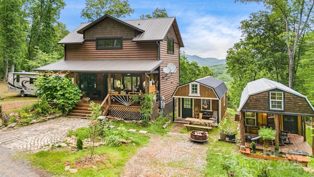43 Dillingham Estates Trl, Swannanoa, NC 28778 - rustic home with covered porch, faux log siding, an outbuilding, an outdoor fire pit, and metal roof