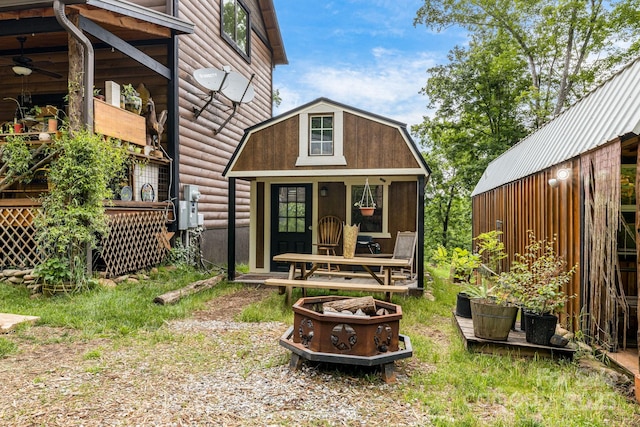 43 Dillingham Estates Trl, Swannanoa, NC 28778 - rear view of house with an outbuilding, a ceiling fan, log veneer siding, and a fire pit