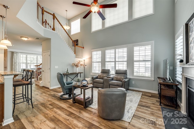 714 Deerbrook Ln, Tega Cay, SC 29708 - living room with a ceiling fan, stairway, wood finished floors, a towering ceiling, and a fireplace