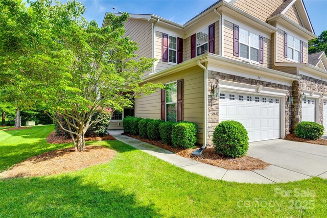 714 Deerbrook Ln, Tega Cay, SC 29708 - view of front of property featuring a front lawn, a garage, stone siding, and concrete driveway