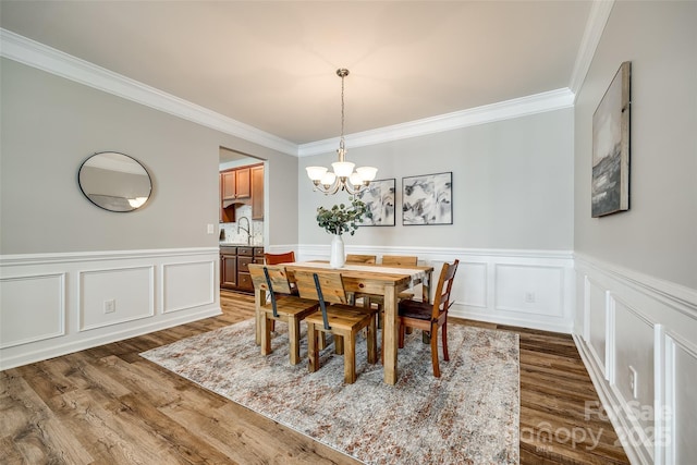 714 Deerbrook Ln, Tega Cay, SC 29708 - dining space featuring a chandelier, ornamental molding, wood finished floors, wainscoting, and a decorative wall