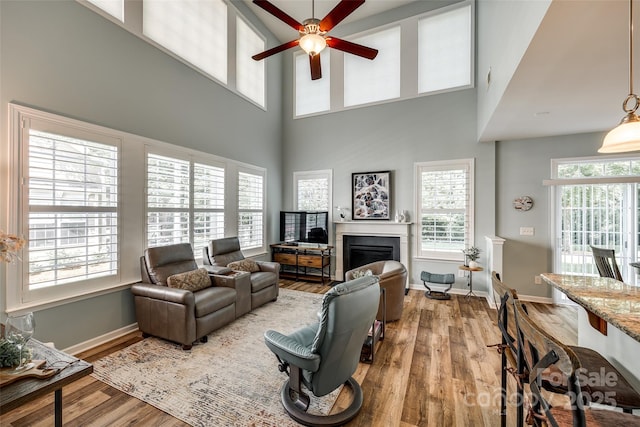 714 Deerbrook Ln, Tega Cay, SC 29708 - living room featuring wood finished floors, a ceiling fan, a fireplace, and a high ceiling