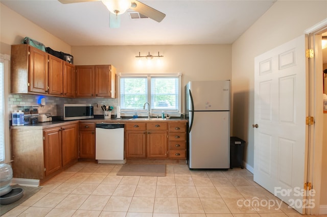 505 S Eastway Dr, Troutman, NC 28166 - kitchen featuring appliances with stainless steel finishes, backsplash, ceiling fan, and brown cabinetry