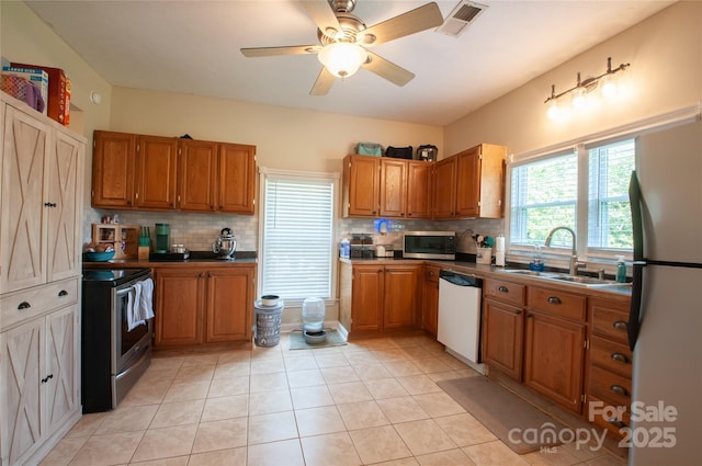 505 S Eastway Dr, Troutman, NC 28166 - kitchen featuring appliances with stainless steel finishes, brown cabinetry, and decorative backsplash