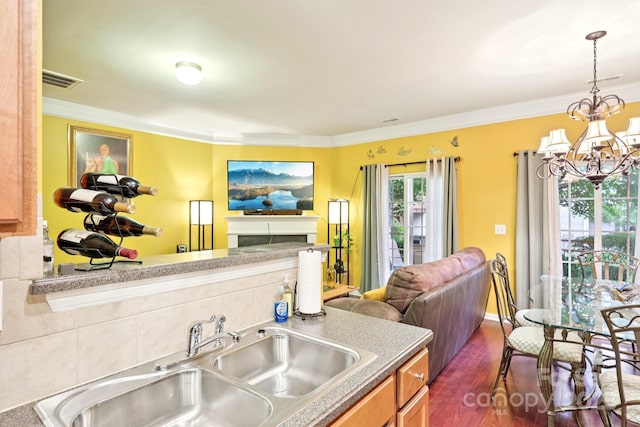 14018 Drake Watch Ln, Charlotte, NC 28262 - kitchen with open floor plan, a sink, a chandelier, crown molding, and dark wood-type flooring