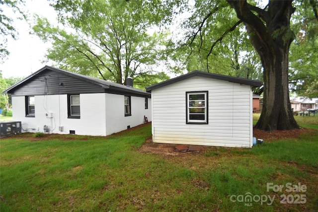 706 Mcintyre St, Monroe, NC 28110 - rear view of property featuring a lawn, central AC, and an outdoor structure
