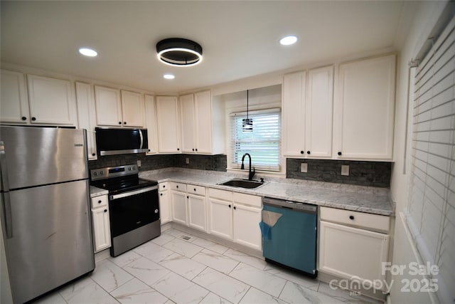706 Mcintyre St, Monroe, NC 28110 - kitchen featuring appliances with stainless steel finishes, a sink, light marble finish floors, recessed lighting, and white cabinets