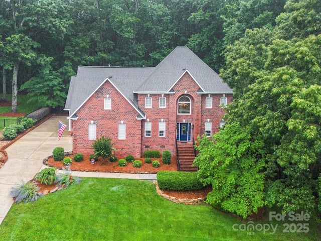 4644 Snow Dr, Harrisburg, NC 28075 - view of front of house with stairs, driveway, a front yard, brick siding, and a wooded view