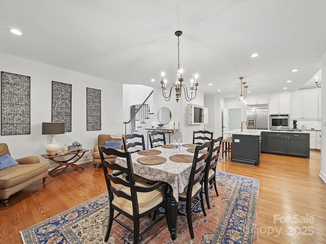 4644 Snow Dr, Harrisburg, NC 28075 - dining room featuring light wood finished floors, stairway, a chandelier, and recessed lighting
