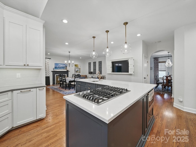 4644 Snow Dr, Harrisburg, NC 28075 - kitchen with stainless steel gas cooktop, a chandelier, recessed lighting, light wood finished floors, and white cabinetry