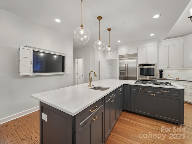 4644 Snow Dr, Harrisburg, NC 28075 - kitchen featuring a sink, stainless steel appliances, white cabinets, light wood-style floors, and a spacious island