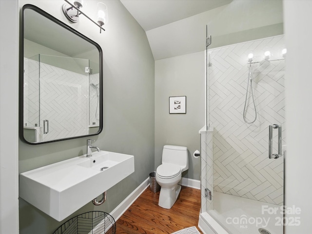 4644 Snow Dr, Harrisburg, NC 28075 - bathroom with toilet, a stall shower, wood finished floors, vaulted ceiling, and baseboards
