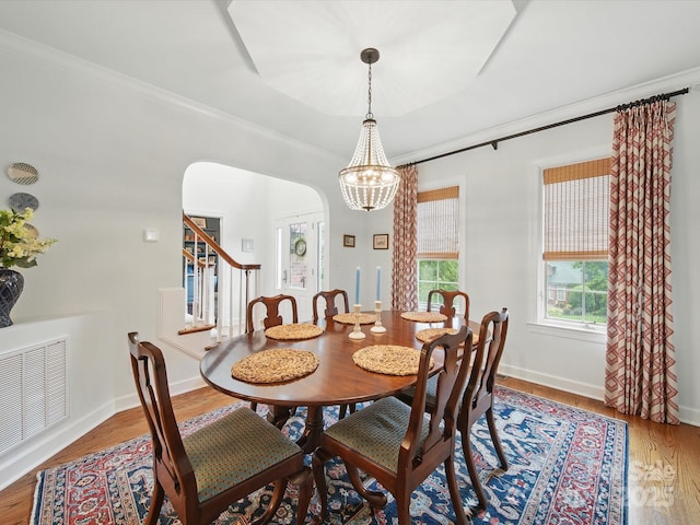 4644 Snow Dr, Harrisburg, NC 28075 - dining area with arched walkways, wood finished floors, stairs, a chandelier, and crown molding