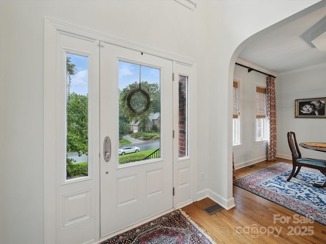 4644 Snow Dr, Harrisburg, NC 28075 - foyer entrance with plenty of natural light, arched walkways, wood finished floors, baseboards, and crown molding
