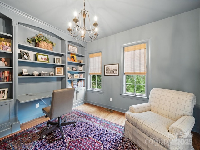 4644 Snow Dr, Harrisburg, NC 28075 - office area with a chandelier, wood finished floors, built in shelves, and baseboards
