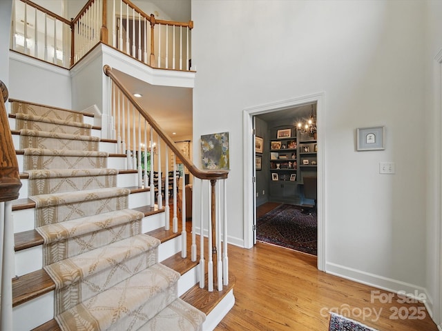 4644 Snow Dr, Harrisburg, NC 28075 - staircase with a high ceiling, wood finished floors, and baseboards