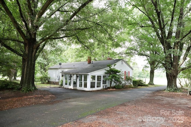 1270 N Enochville Ave, China Grove, NC 28023 - rear view of house with a chimney, a sunroom, asphalt driveway, and roof with shingles