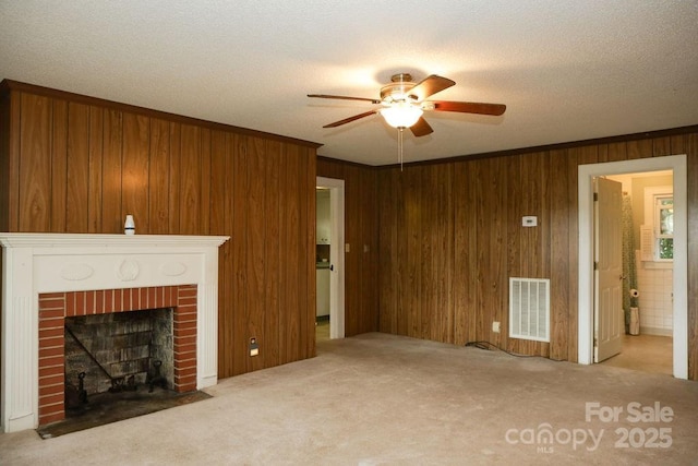 1270 N Enochville Ave, China Grove, NC 28023 - unfurnished living room with a ceiling fan, carpet floors, a fireplace, wooden walls, and a textured ceiling
