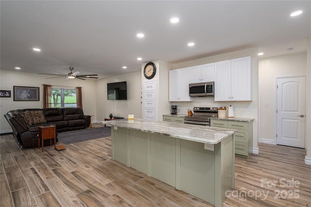 3103 Richview Dr, Crouse, NC 28033 - kitchen with stainless steel appliances, white cabinets, light wood-style flooring, a kitchen island, and recessed lighting