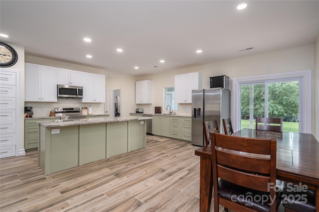 3103 Richview Dr, Crouse, NC 28033 - kitchen with appliances with stainless steel finishes, a sink, light wood-style flooring, a center island, and plenty of natural light