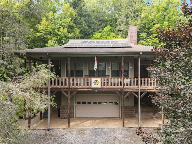 305 Pound Mill Branch Rd, Green Mountain, NC 28740 - view of front of house featuring dirt driveway, roof mounted solar panels, a chimney, and a shingled roof