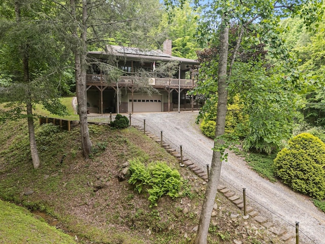 305 Pound Mill Branch Rd, Green Mountain, NC 28740 - view of front of property featuring dirt driveway, a chimney, a deck, and an attached garage