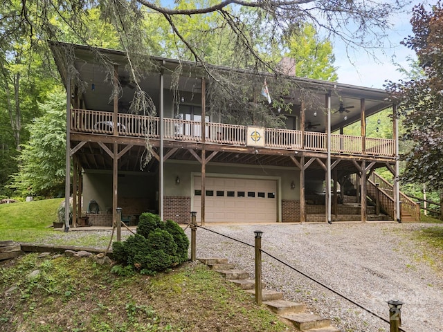 305 Pound Mill Branch Rd, Green Mountain, NC 28740 - view of front facade with stairs, gravel driveway, a wooden deck, and an attached garage