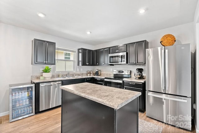 999 Rushing Ln Unit 13, Fort Mill, SC 29715 - kitchen featuring appliances with stainless steel finishes, wine cooler, a center island, light countertops, and light wood-style flooring