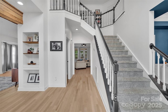 15737 Agincourt Dr, Huntersville, NC 28078 - stairway featuring wood finished floors, built in shelves, baseboards, a high ceiling, and recessed lighting