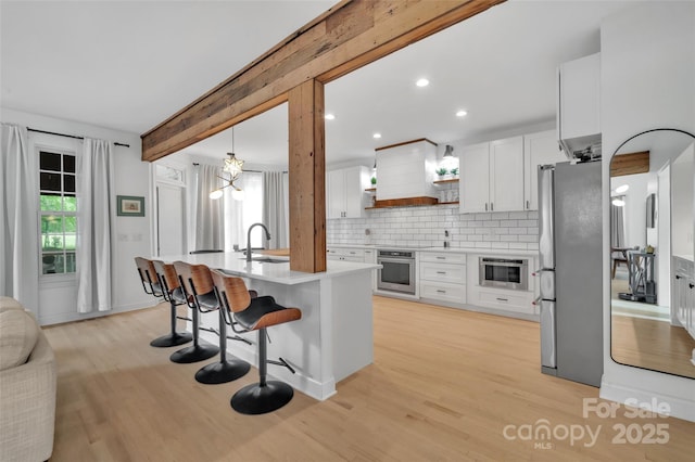 15737 Agincourt Dr, Huntersville, NC 28078 - kitchen featuring appliances with stainless steel finishes, open shelves, light countertops, decorative backsplash, and light wood-type flooring