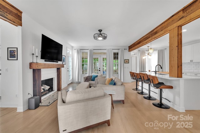 15737 Agincourt Dr, Huntersville, NC 28078 - living room featuring light wood-style flooring, a fireplace, baseboards, french doors, and beamed ceiling