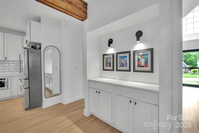 15737 Agincourt Dr, Huntersville, NC 28078 - kitchen with appliances with stainless steel finishes, white cabinetry, light wood-style floors, decorative backsplash, and light countertops