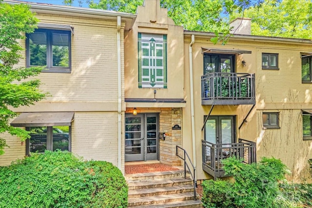 201 N Dotger Ave Unit C8, Charlotte, NC 28207 - view of exterior entry with french doors, a balcony, brick siding, and stucco siding