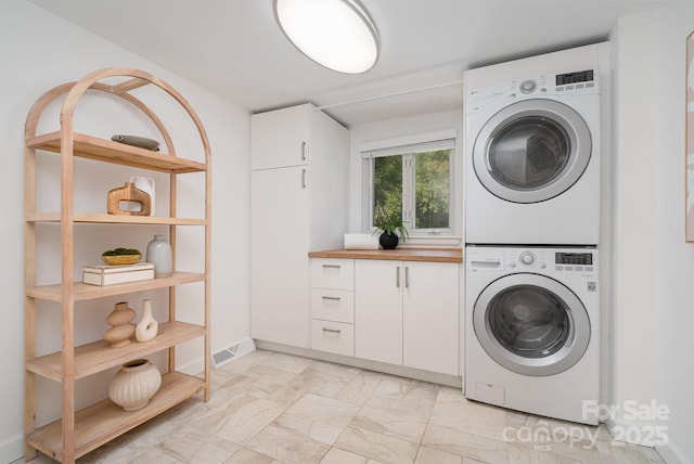 5424 Doncaster Dr, Charlotte, NC 28211 - laundry room with stacked washer / drying machine, cabinet space, and light marble finish flooring